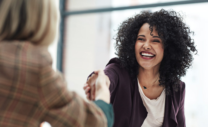 Two women shake hands at a job interview