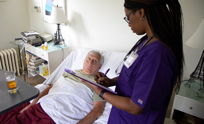 A VITAS provider talks to a patient who has oxygen tubes