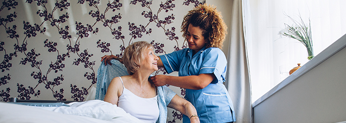 Caretaker helping patient get dressed