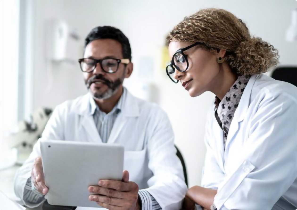 Two clinicians review patient records on an iPad
