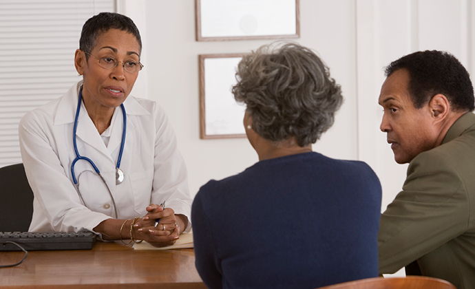 A couple talks with their physician in an office